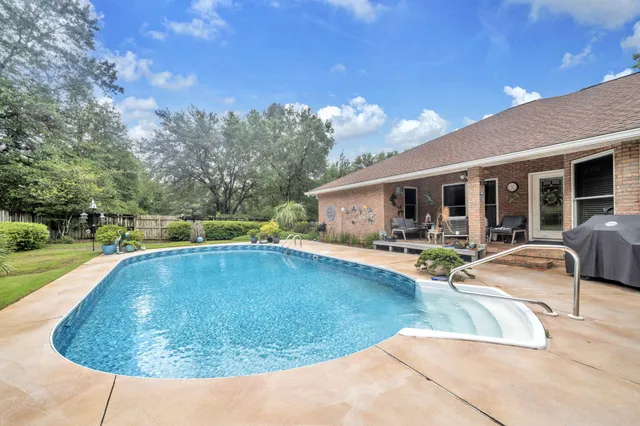 a front view of house with yard swimming pool and green space