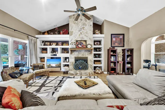 a living room with furniture a fireplace and a chandelier