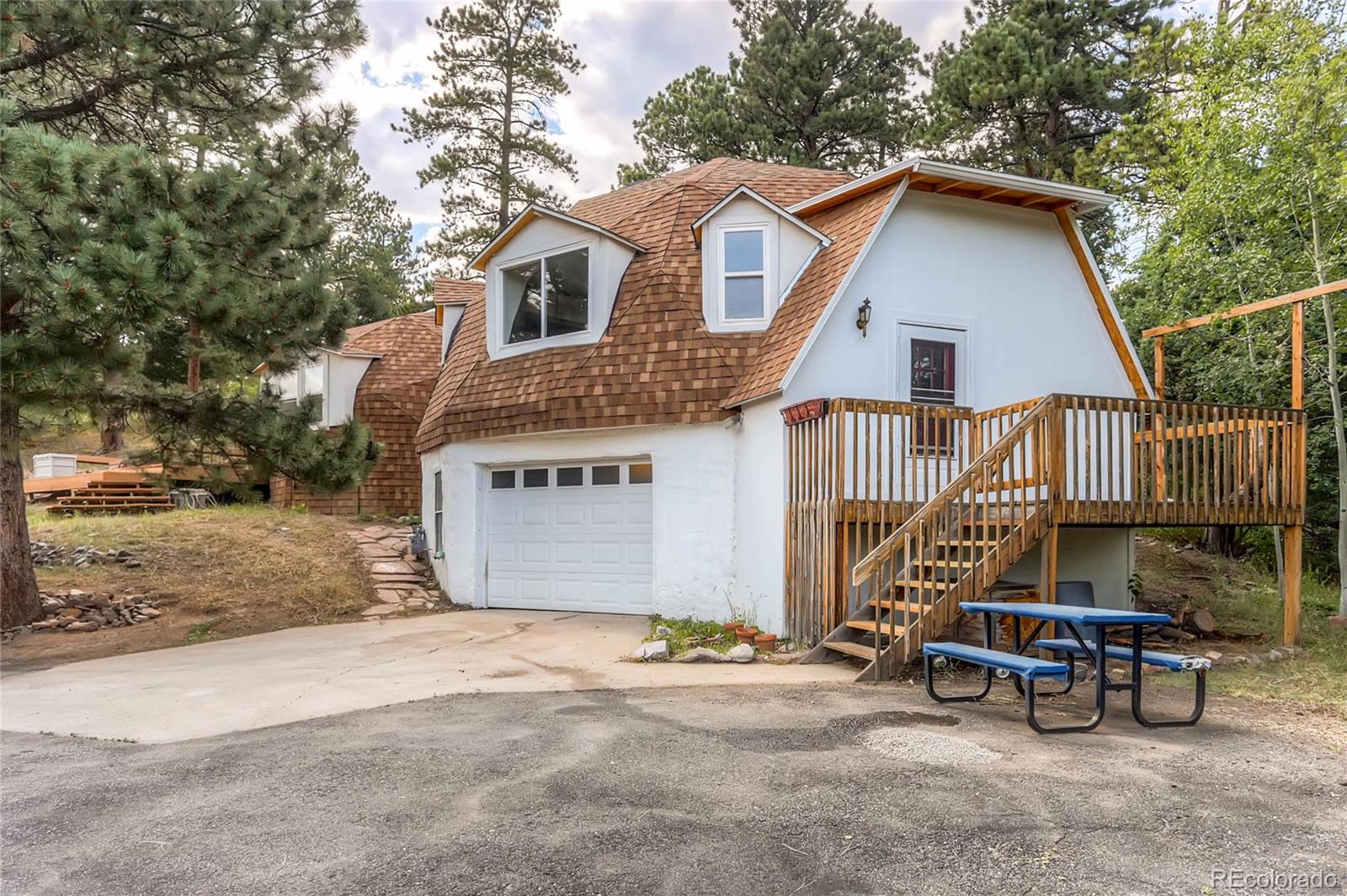 11648 Ranch Elsie Road Golden, CO 80403 - Photo 2 of 13 a view of a house with a yard and large trees