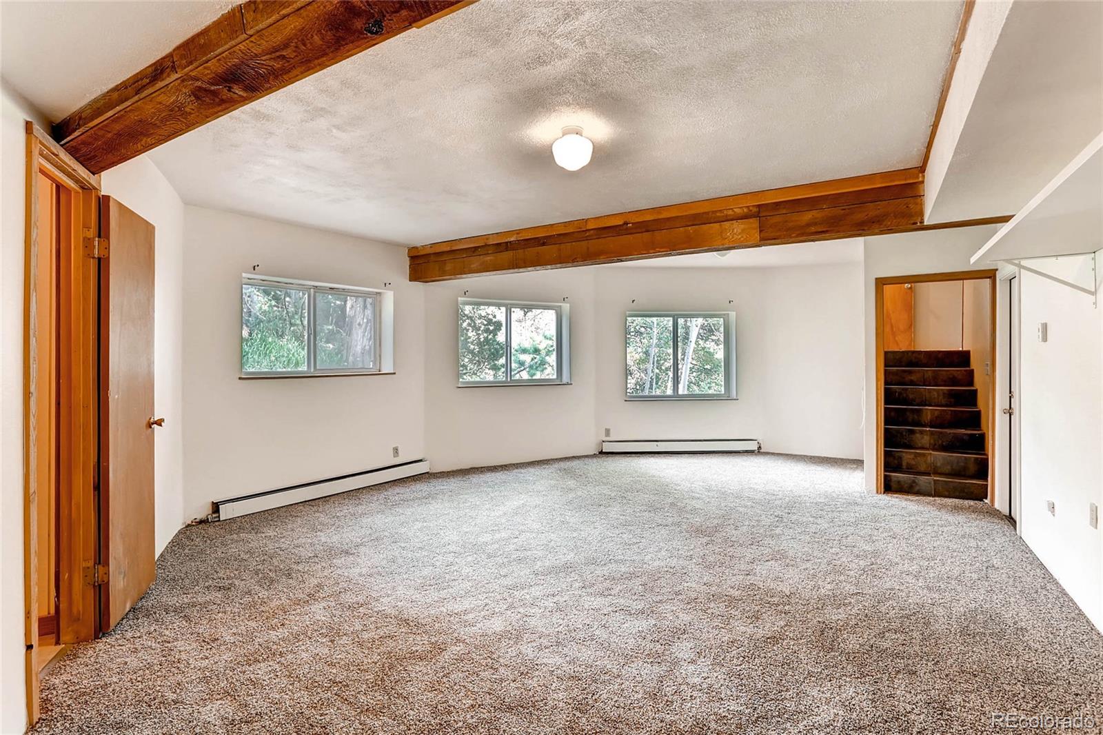 11648 Ranch Elsie Road Golden, CO 80403 - Photo 8 of 13 an empty room with windows and closet