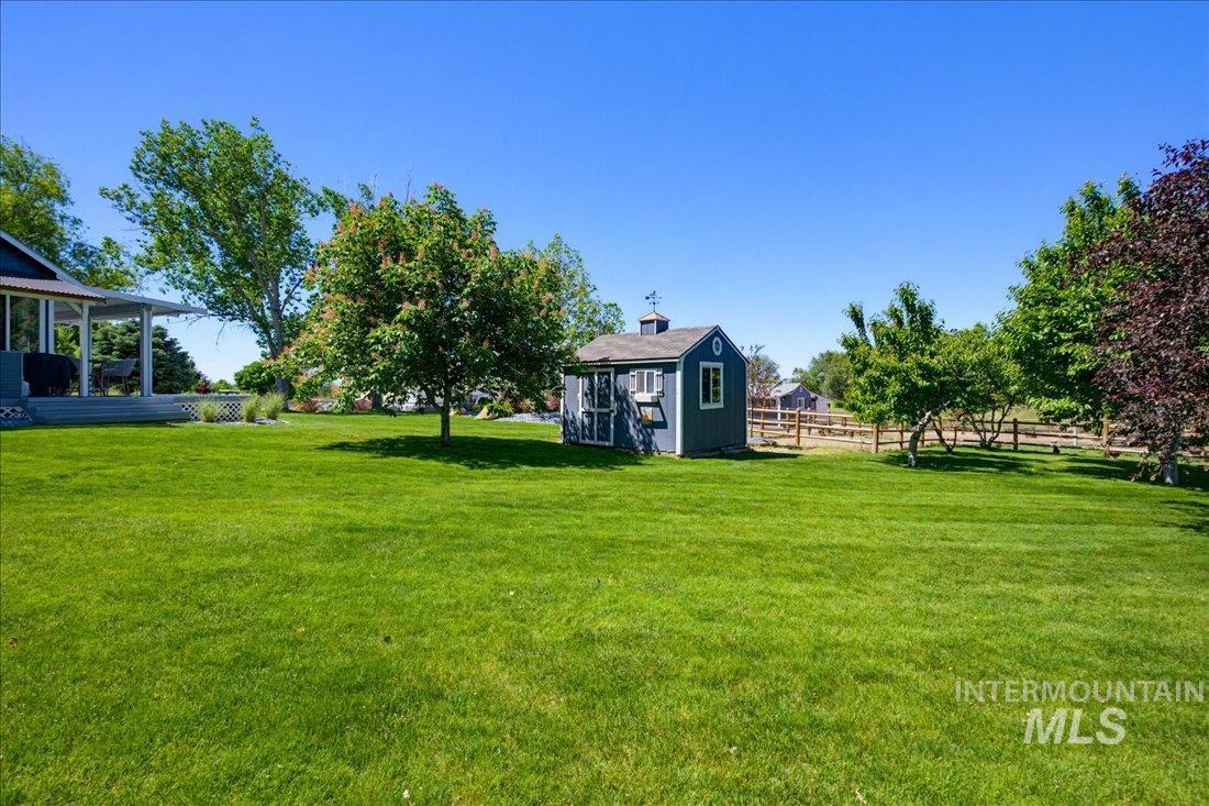 24623 Falcon Lane Caldwell, ID 83607 - Photo 28 of 40 Expansive green lawn with mature trees and a detached shed