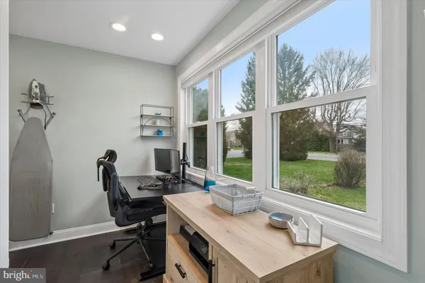a view of a workspace with furniture and a window