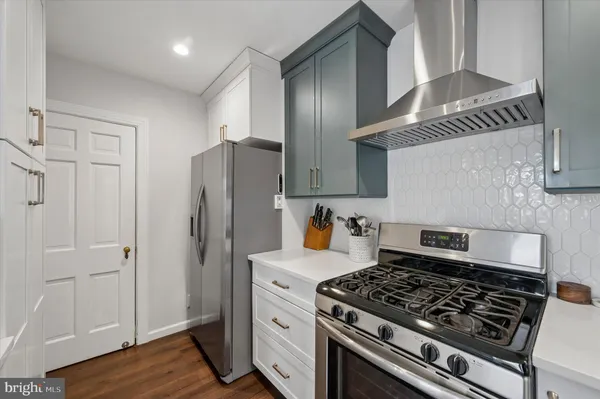 a kitchen with granite countertop a stove and a refrigerator