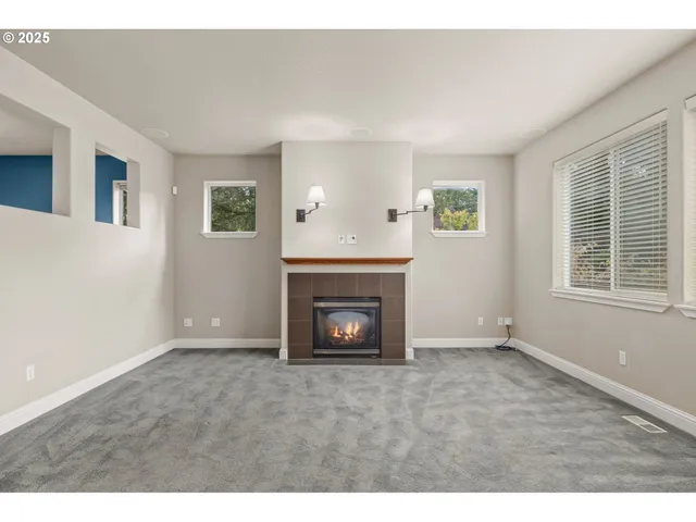 a view of an empty room with window and fire place