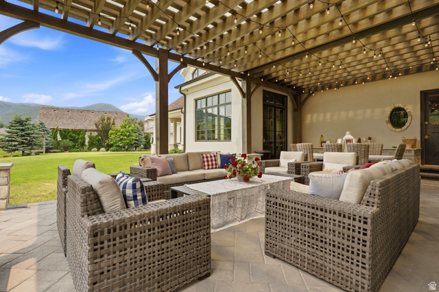 71 Farm Road Midway, UT 84049 - Photo 29 of 92 Expansive paver patio with a wooden pergola, string lighting, and ample seating areas