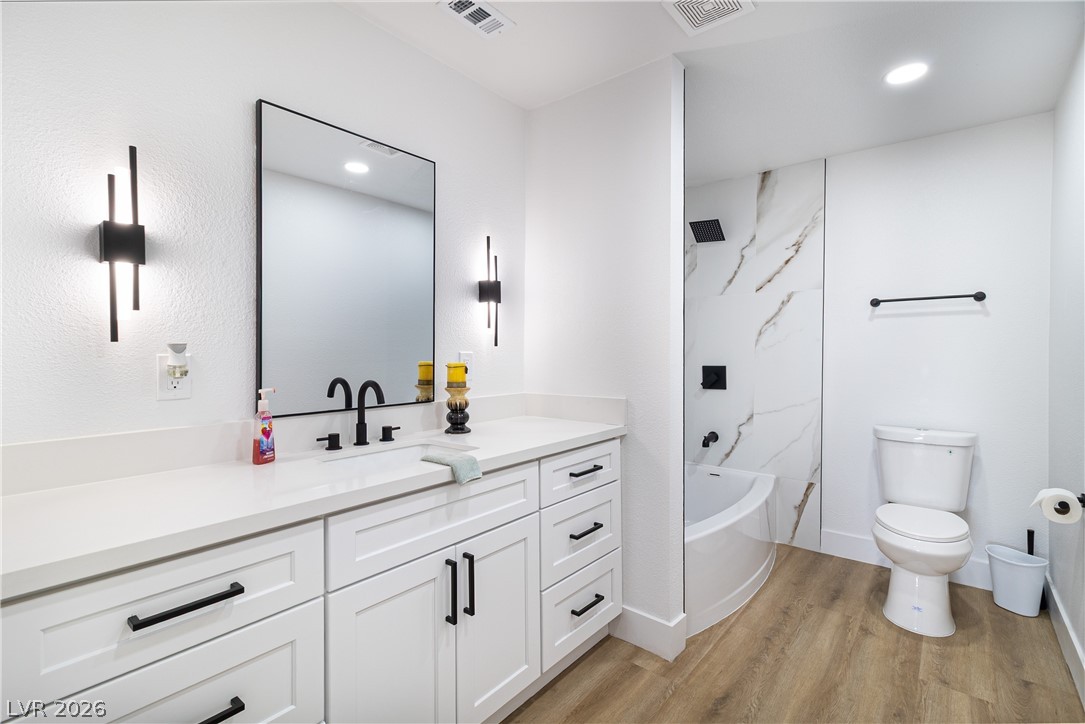 1891 Brian Road Pahrump, NV 89048 - Photo 22 of 50 Bathroom with visible vents, toilet, vanity, and wood finished floors