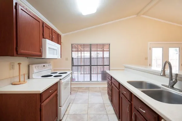 a kitchen with a sink stove top oven and cabinets