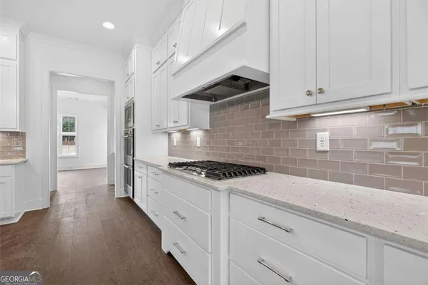 a view of a livingroom with a ceiling fan window and a kitchen