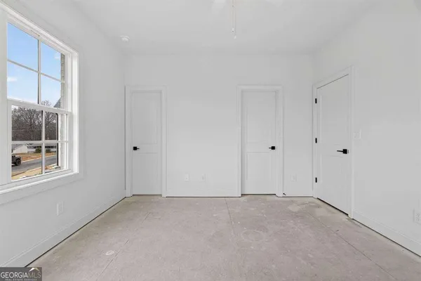 an empty room with windows and closet