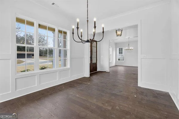 a kitchen with kitchen island granite countertop stainless steel appliances a sink and a chandelier