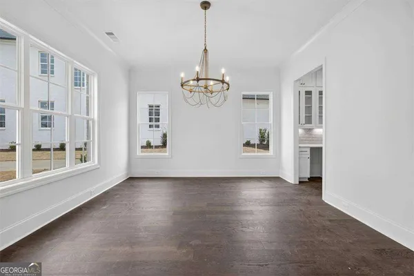 a kitchen with kitchen island granite countertop stainless steel appliances cabinets a sink and a wooden floor