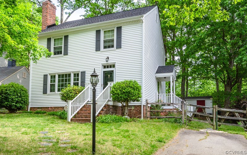 a view of house with a backyard and chairs