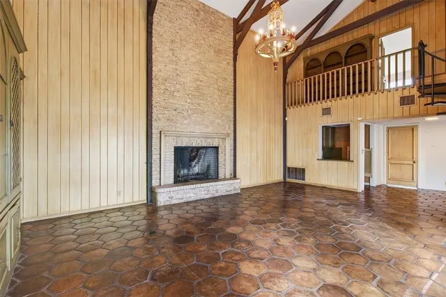 a view of an empty room with a fireplace and a window