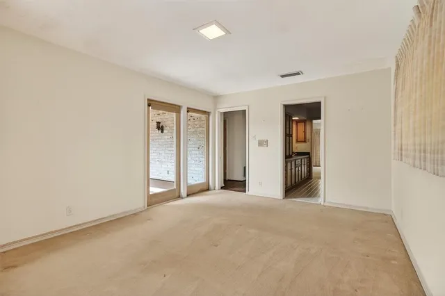 a view of an empty room with closet and a window