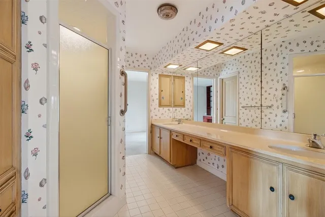 a large bathroom with a granite countertop double vanity sink mirror and shower