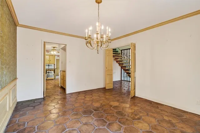 a view of a hallway with wooden floor and a chandelier