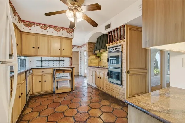 a kitchen with stainless steel appliances granite countertop a stove a sink and a refrigerator