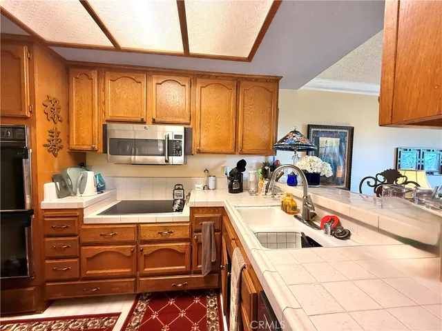 a kitchen with a stove a sink a refrigerator and cabinets