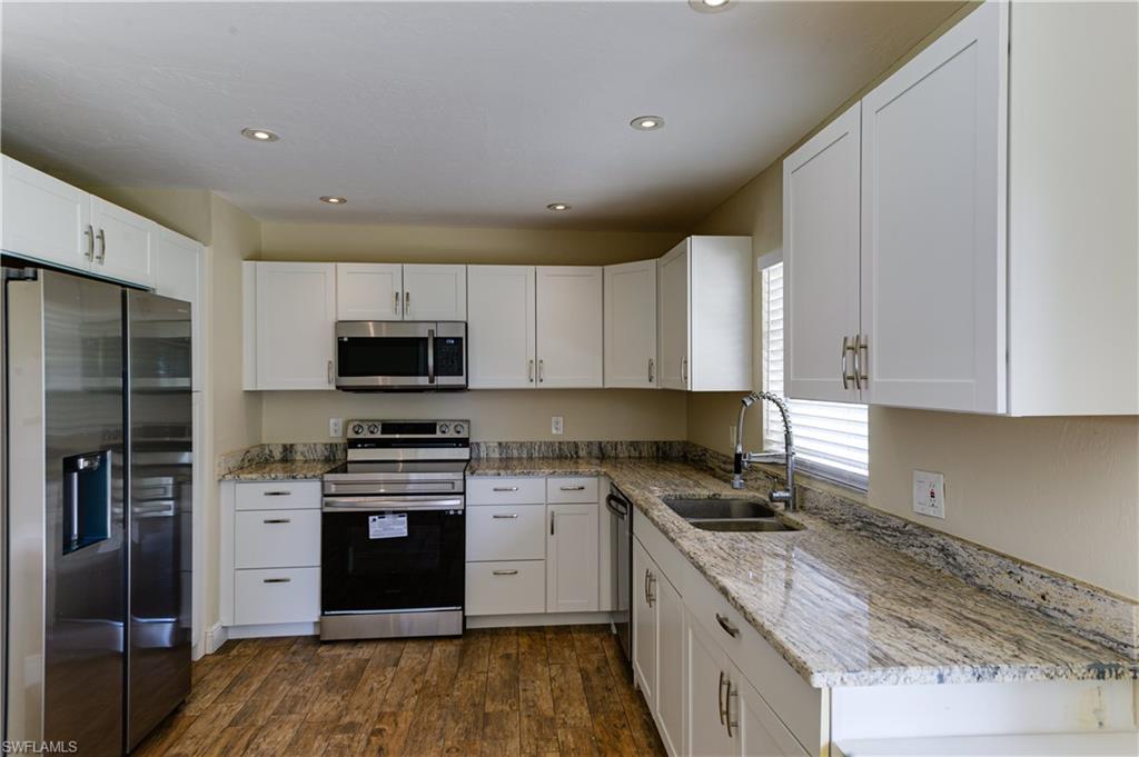 Undisclosed Address Naples, FL 34116 - Photo 8 of 18 a kitchen with stainless steel appliances granite countertop a stove a sink and a refrigerator