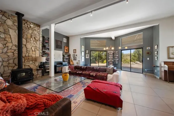 a living room with furniture kitchen view and a window