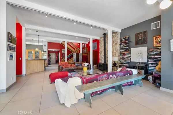 a kitchen with stainless steel appliances granite countertop a refrigerator a stove a sink a dining table and chairs with wooden floor