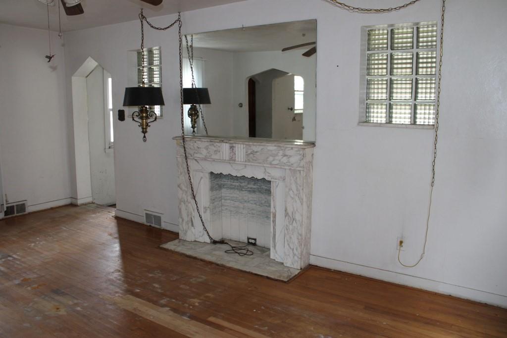 825 Liberty Street Duquesne, PA 15110 - Photo 5 of 25 an empty room with wooden floor a fireplace and windows