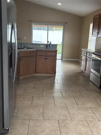 a kitchen with stainless steel appliances granite countertop a refrigerator and a sink