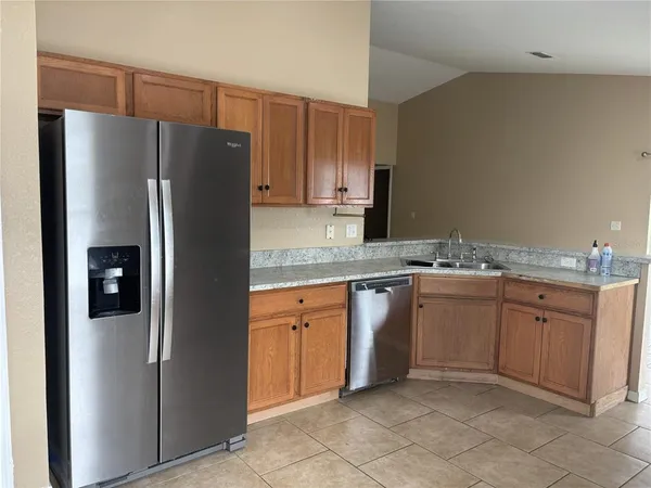 a kitchen with stainless steel appliances granite countertop a refrigerator and a sink