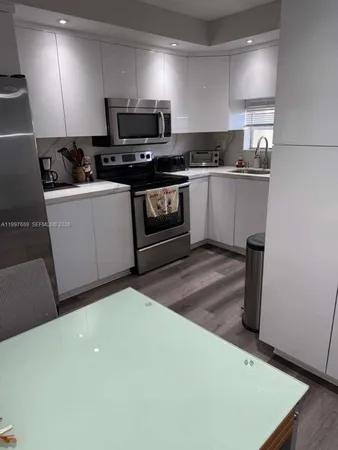 a kitchen with a sink a stove and cabinets