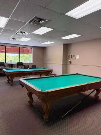 a room with pool table and windows