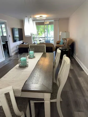 a view of a dining room with furniture a chandelier and wooden floor