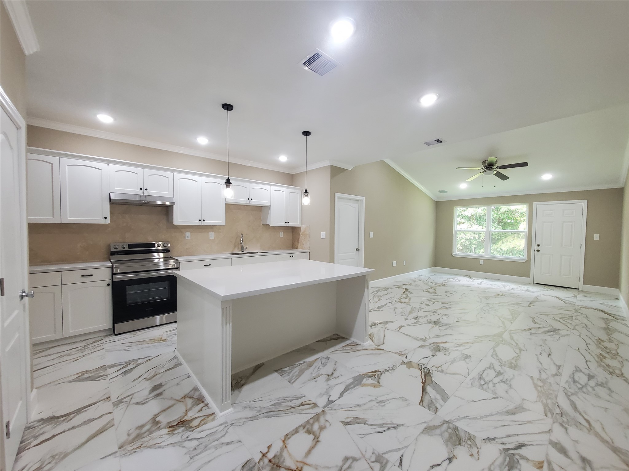 1306 North 9th Street Conroe, TX 77301 - Photo 5 of 47 a large white kitchen with kitchen island a sink stainless steel appliances and cabinets