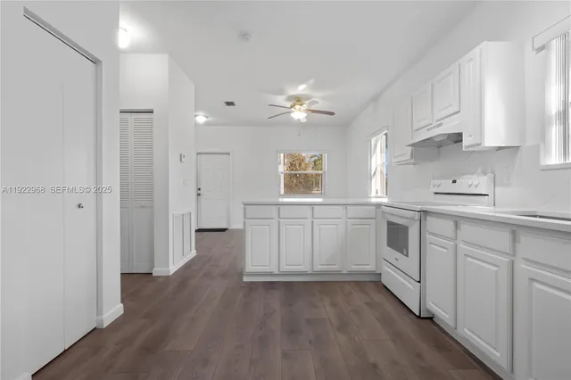 a kitchen with white cabinets and white appliances