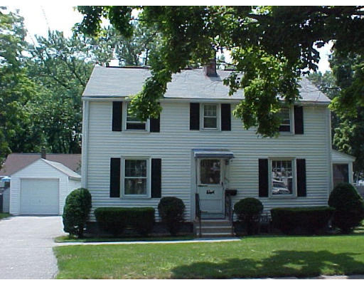 a front view of a house with yard and green space