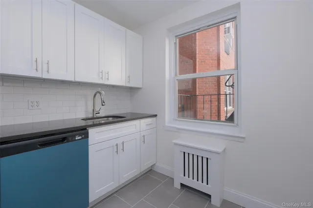 a kitchen with granite countertop white cabinets and sink