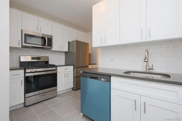 a kitchen with stainless steel appliances granite countertop a sink dishwasher a refrigerator and a microwave