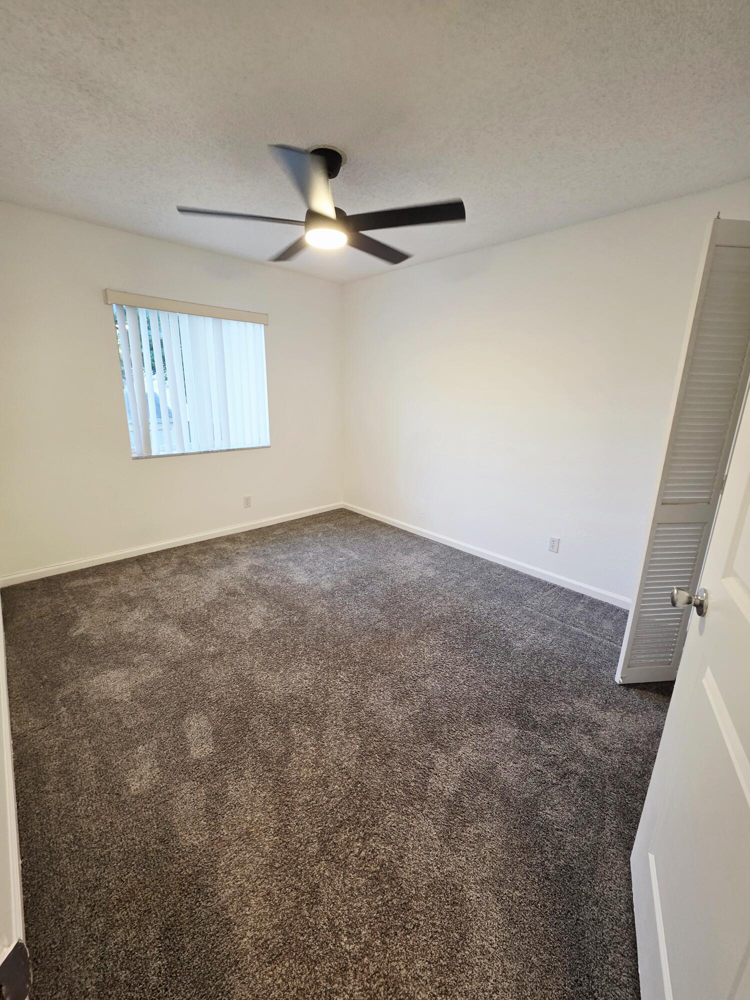10851 Palm Ridge Lane Tamarac, FL 33321 - Photo 20 of 40 an empty room with windows and fan