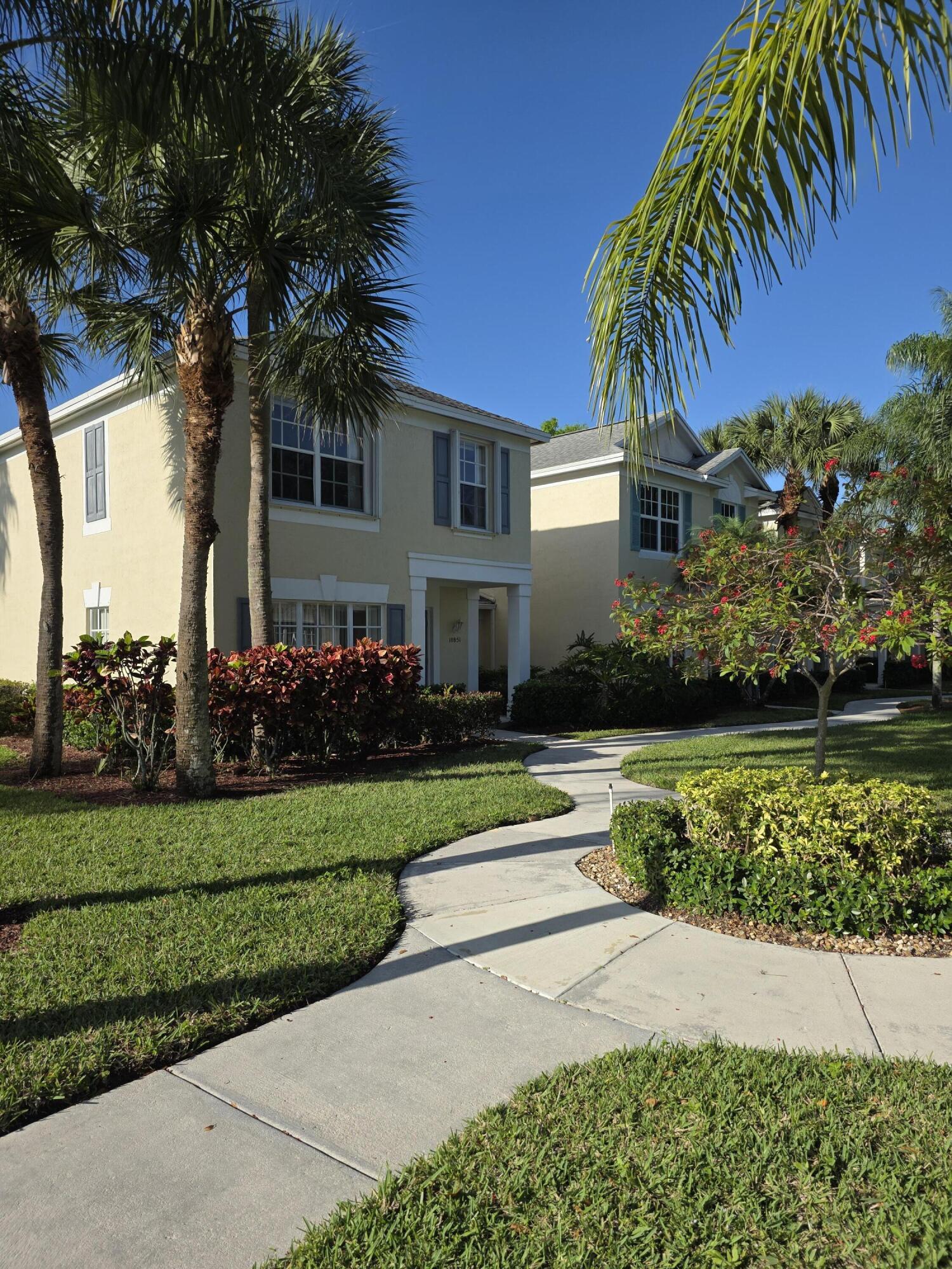10851 Palm Ridge Lane Tamarac, FL 33321 - Photo 2 of 40 a front view of a house with a garden and tree