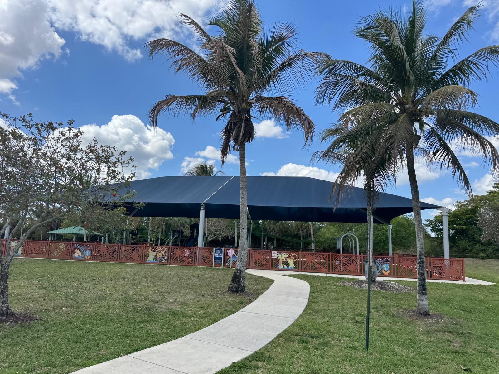 10851 Palm Ridge Lane Tamarac, FL 33321 - Photo 37 of 40 a view of a yard with table and chairs under an umbrella