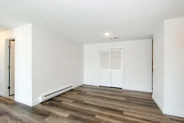 a view of empty room with wooden floor