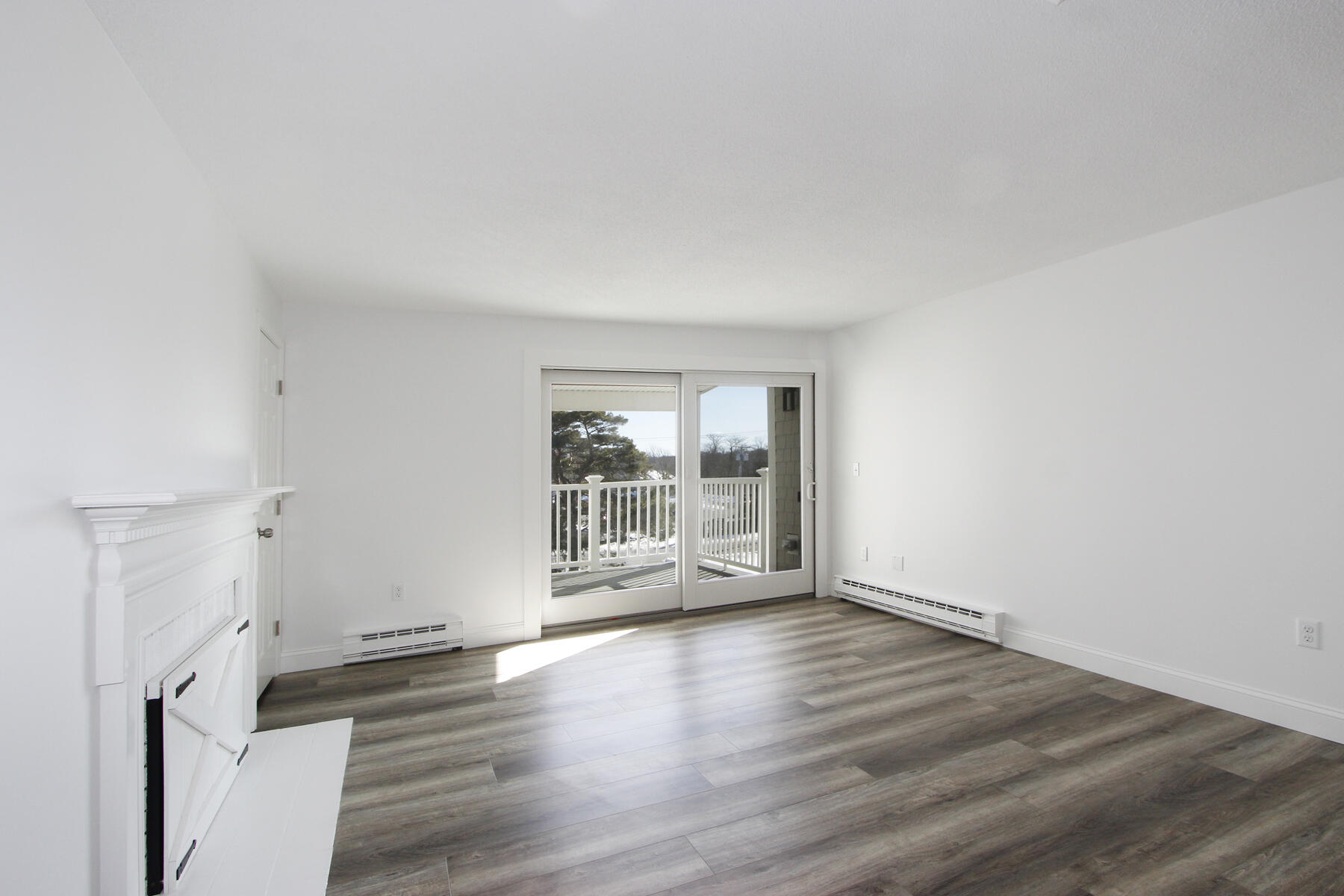 36 Old Colony Way, Unit 21 Orleans, MA 02653 - Photo 8 of 25 an empty room with wooden floor and windows