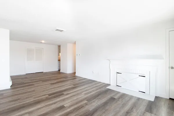 a view of empty room with wooden floor