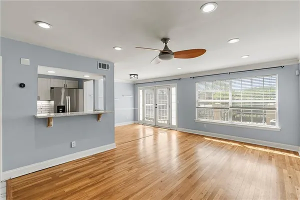 a view of an empty room with a window and wooden floor