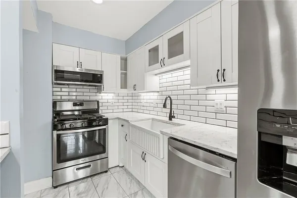 a kitchen with cabinets stainless steel appliances and sink