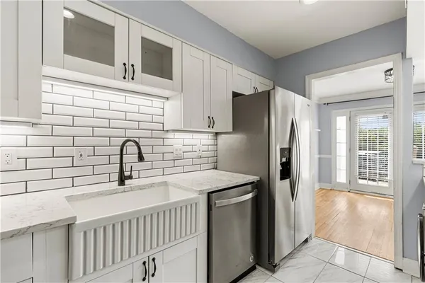 a kitchen with stainless steel appliances granite countertop a refrigerator and a sink