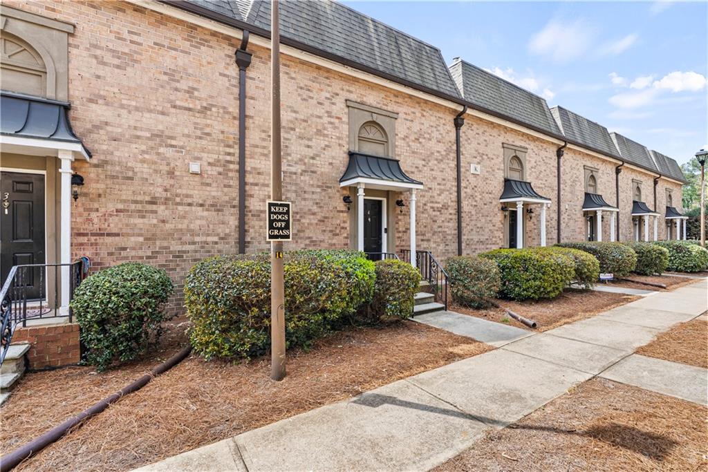 6980 Roswell Road, Unit K4 Atlanta, GA 30328 - Photo 2 of 31 a front view of a house with garden