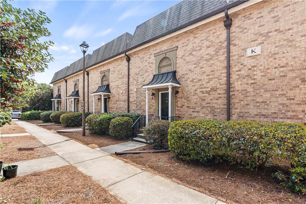 6980 Roswell Road, Unit K4 Atlanta, GA 30328 - Photo 3 of 31 a view of a front of a house with a yard
