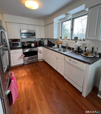 a kitchen with granite countertop a stove a sink and a microwave