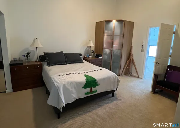 a bedroom with a bed and a flat tv screen on dresser