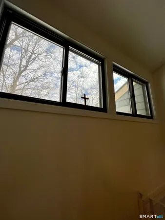 a bed sitting in a bedroom next to a window with a book shelf